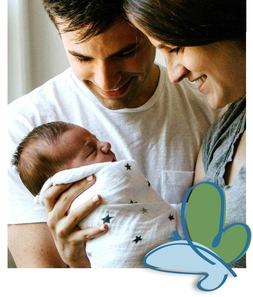 Ein Mann und eine Frau lächeln ein schlafendes Baby an, das sie halten. Das Baby ist in eine weiße Decke mit Sternen gewickelt.