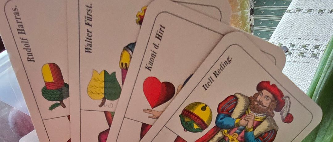 Mehrere Spielkarten mit verschiedenen Illustrationen sind mit Radieschen und einer weißen Kerze auf einem Tisch angeordnet. Jede Karte hat ein einzigartiges Design und Text.