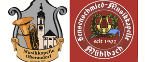 Ein musikalisches Emblem mit einer Tuba und einem Kirchturm mit Uhr, begleitet von einem Banner mit der Aufschrift 'Musikkapelle Oberaudorf'.