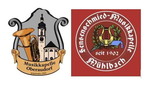 Ein musikalisches Emblem mit einer Tuba und einem Kirchturm mit Uhr, begleitet von einem Banner mit der Aufschrift 'Musikkapelle Oberaudorf'.