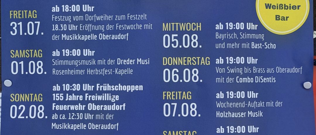 Ein blaues Plakat mit dem Zeitplan für das 54. Festival des FV Oberaudorf vom 31. Juli bis 9. August 2026. Es enthält tägliche Veranstaltungen, Zeiten und Beschreibungen.