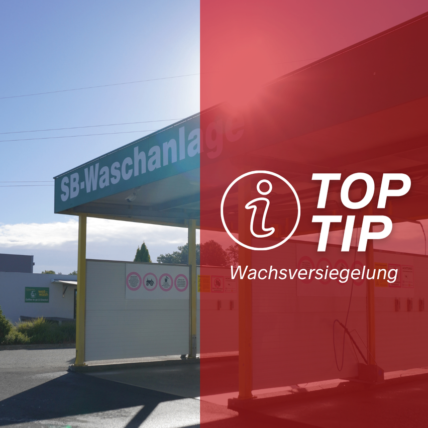 Eine Außenwaschanlage mit dem Schild SB-Waschanlage. Die Station hat ein Vordach und eine rote Wand. Es gibt auch ein Top-Tip-Schild. Auf der linken Seite befindet sich ein Gebäude mit einem grünen Schild.