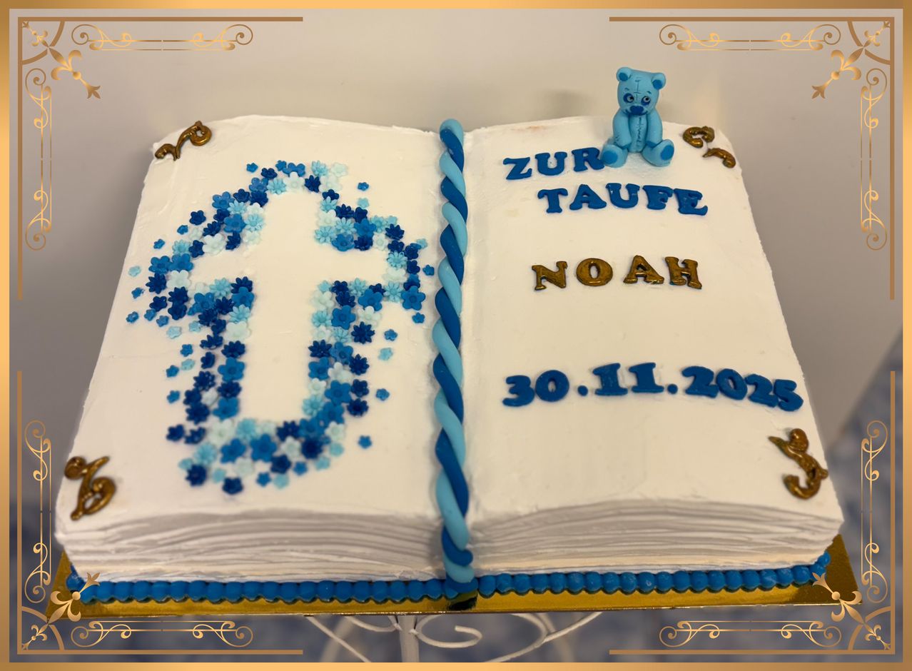 Ein Kuchen in Form eines offenen Buches mit blauen Blumen und einem Teddybär. Darauf steht 'Zur Taufe Noah 30.11.2025'.