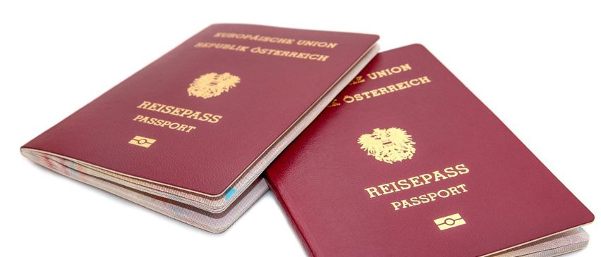 Zwei burgunderrote österreichische Pässe mit goldenen Emblemen auf weißem Hintergrund. Der Text lautet 'Reisepass' und 'Republik Osterreich'. Die Pässe haben goldene Buchstaben und ein goldenes Emblem.