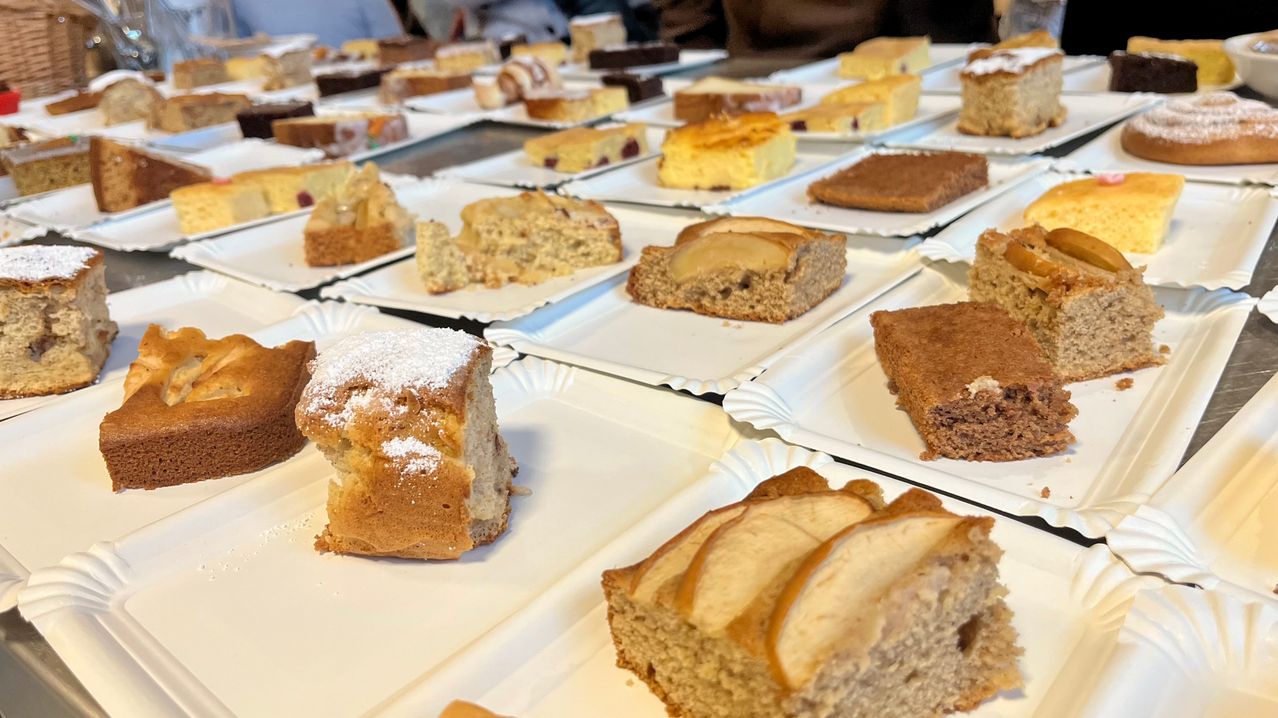 Ein Tisch voller verschiedener Desserts, einschließlich Kuchen, Apfelscheiben und ein Stück Brot. Jedes Dessert steht auf einem weißen Teller.