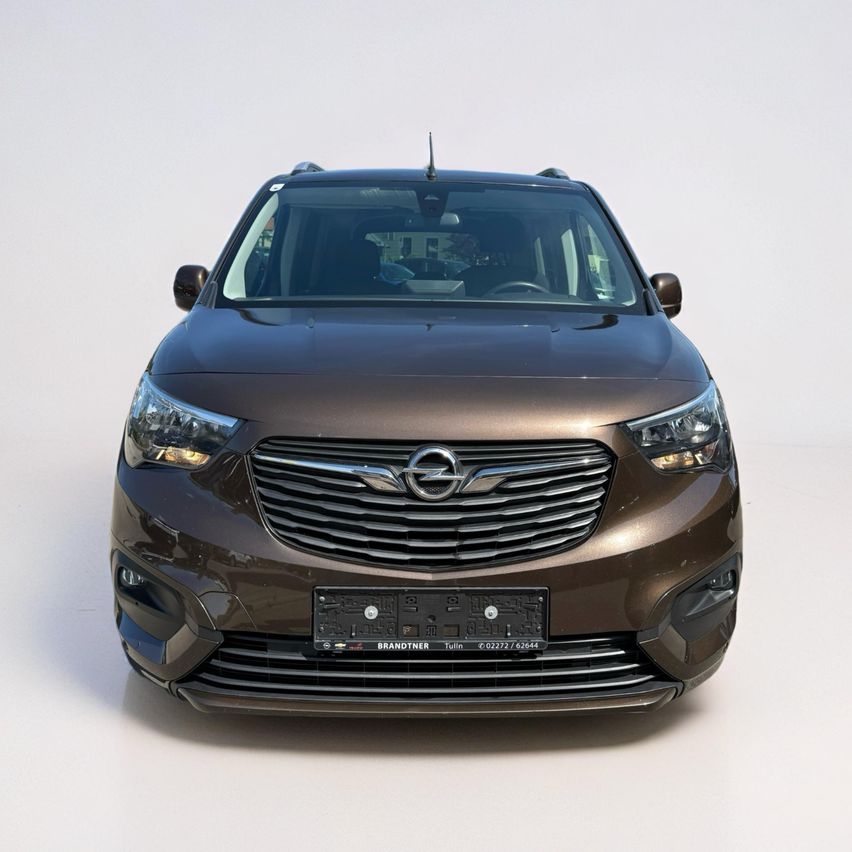 Ein brauner Opel-Minivan mit einem großen Kühlergrill und Scheinwerfern ist vorne ausgestellt. Das Nummernschild zeigt 'BRANDTNER' und 'Tulln'. Der Wagen ist vor einem weißen Hintergrund ausgestellt.