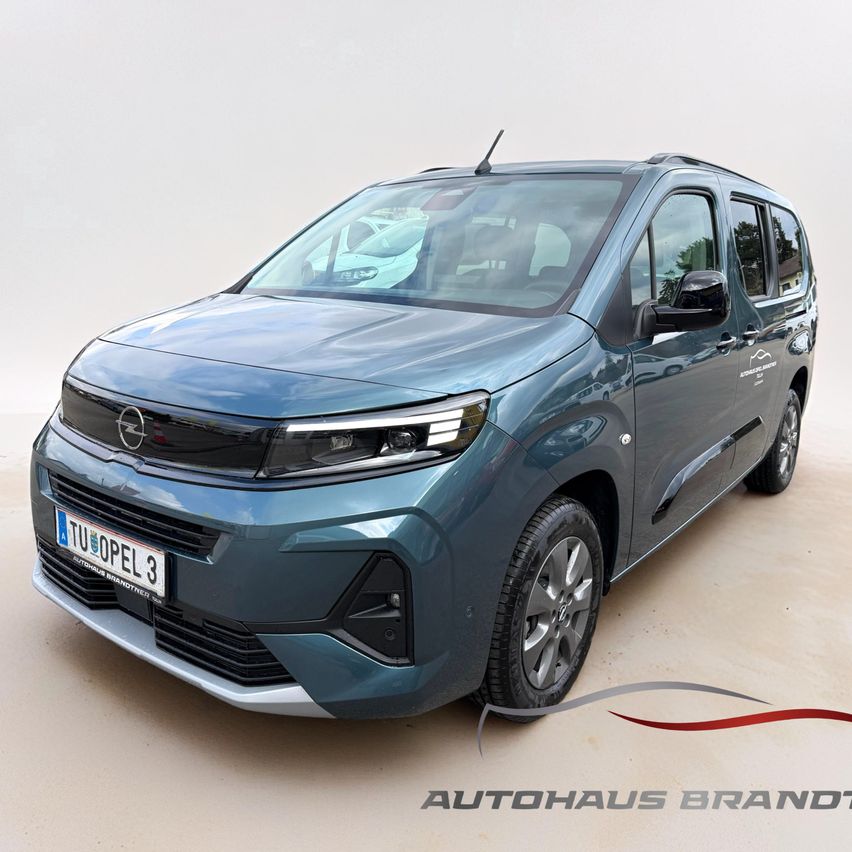 Ein blauer Opel-Minivan mit einem Nummernschild ist in einer Garage geparkt. Die Vorderseite des Autos zeichnet sich durch eine charakteristische Kühlergrill und Scheinwerfer aus. Das Bild ist mit dem Text 'AUTOHAUS BRANDT' versehen.