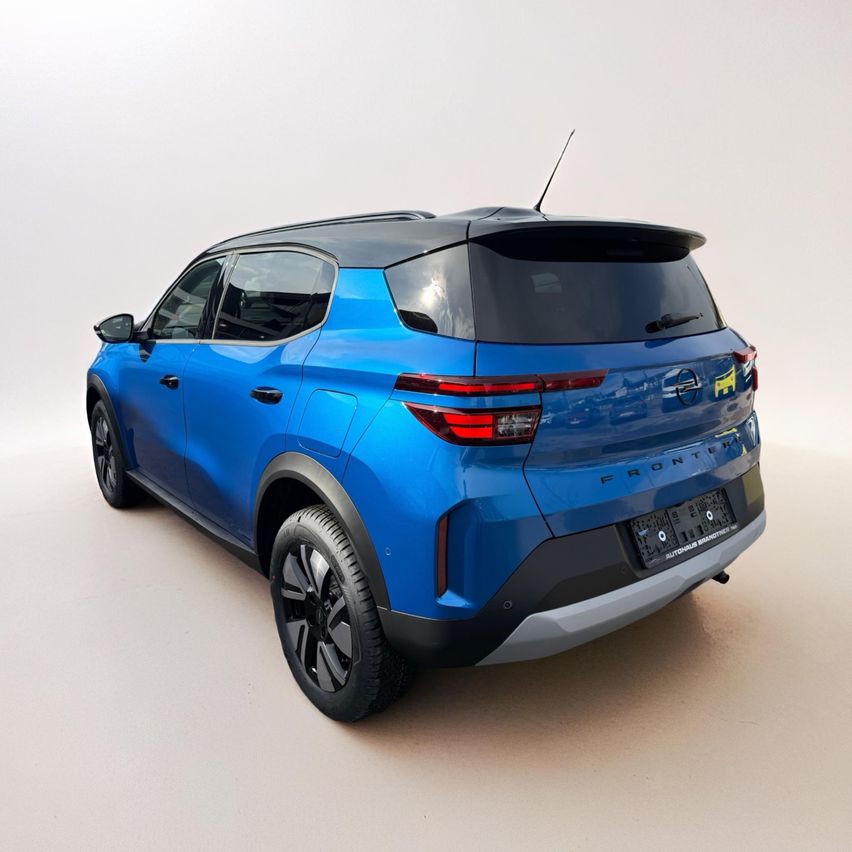 Die Heckansicht eines blauen SUV ist zu sehen. Es hat einen Spoiler auf der Kofferraumklappe und rote Bremslichter.