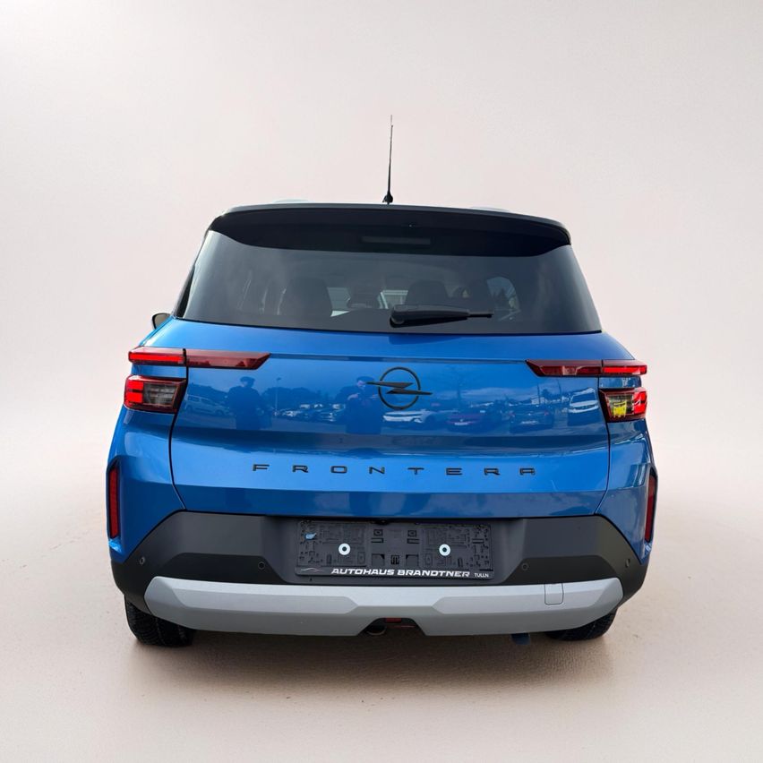 Die Heckansicht eines blauen Opel Frontera SUV mit Nummernschild und Antenne.