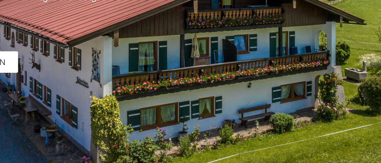 Ein Haus in Bodnerlehen, eingebettet in einer der schönsten Regionen der Alpen, mit einem großen Badegarten und Bergen im Hintergrund.