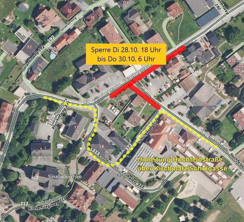 Luftaufnahme eines Wohngebiets mit markierten Straßensperrungen. Sperre Di 28.10. 18 Uhr bis Do 30.10. 6 Uhr und Umleitung Hochfeldstrasse uber Kirchplatz/Schulgasse sind angegeben.