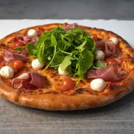 Eine frisch gebackene Pizza mit goldener Kruste, belegt mit Mozzarella, Kirschtomaten, Prosciutto und Rucola.