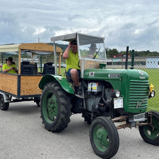 Bild enthält, Adult, Male, Man, Person, Wheel, Vehicle, Tractor, Hat, Outdoors, Face