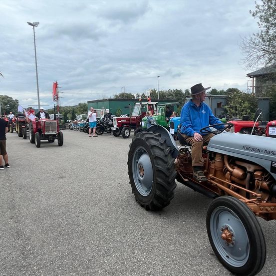 Bild enthält, Person, Tractor, Vehicle, Adult, Male, Man, Tire, Shoe, Wheel, Shorts