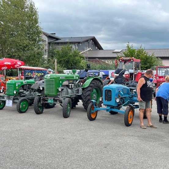 Bild enthält, Person, Machine, Wheel, Tractor, Vehicle, Clothing, Footwear, Shoe, Shorts, Outdoors