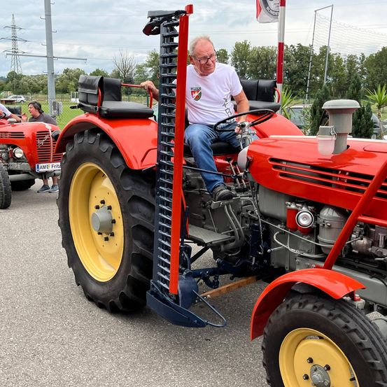 Bild enthält, Adult, Male, Man, Person, Tractor, Vehicle, Outdoors, Wheel, Nature, Glasses