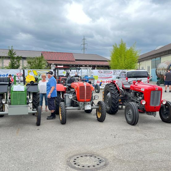 Bild enthält, Tractor, Vehicle, Person, Footwear, Shoe, Machine, Wheel, Shorts, Wristwatch, Car