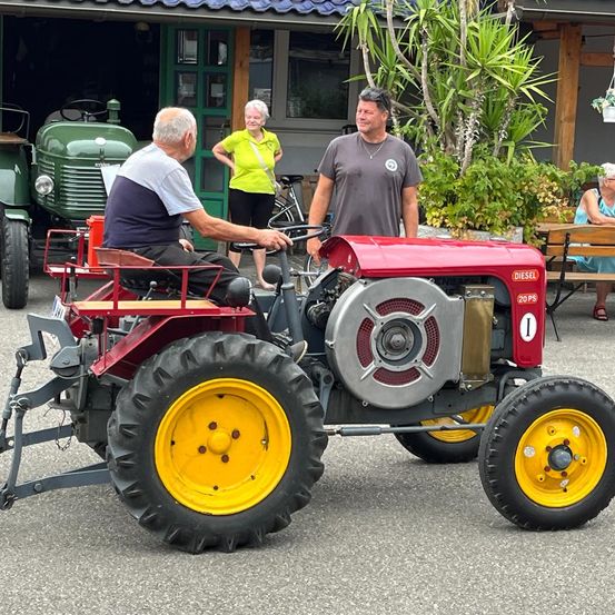 Bild enthält, Wheel, Adult, Male, Man, Person, Necklace, Tractor, Vehicle, Tire, Outdoors