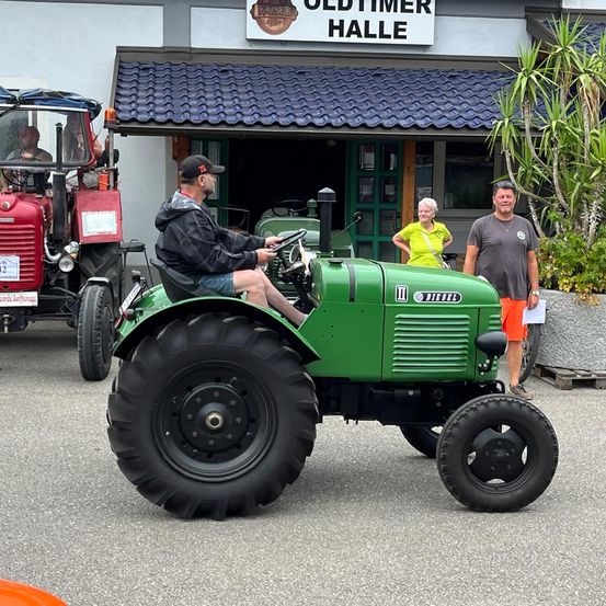 Bild enthält, Adult, Male, Man, Person, Tractor, Vehicle, Tire, Wheel, Necklace, Shoe
