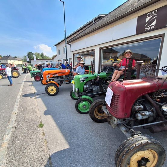 Bild enthält, Person, Tractor, Vehicle, Wheel, Car, Hat, Head, Glasses, Helmet, Outdoors