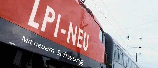 Ein roter Zug mit der Aufschrift LPI-NEU mit neuem Schwung. Der Zug hat viele Fenster und befindet sich unter einer Oberleitung.