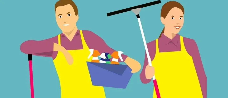 Zwei Personen in gelben Schürzen, eine hält einen Korb mit Reinigungsutensilien, die andere einen Besen. Beide lächeln und sehen bereit für Reinigungsaufgaben aus.