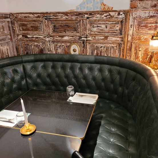 Bild enthält, Indoors, Interior Design, Couch, Furniture, Table, Living Room, Tabletop, Restaurant, Candle, Wood