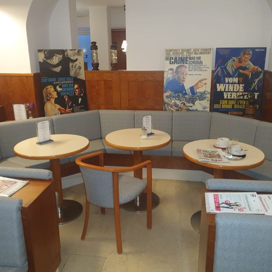 Bild enthält, Furniture, Indoors, Lounge, Table, Person, Chair, Cup, Dining Table, Foyer, Man