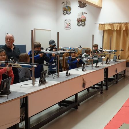 Bild enthält, People, Person, Firearm, Gun, Rifle, Weapon, Boy, Child, Male, Classroom