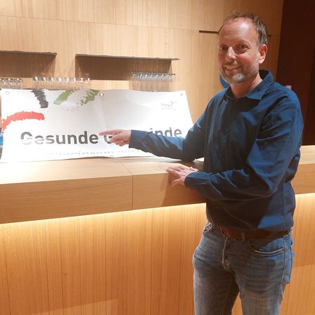 Bild enthält, Pants, Plywood, Wood, Table, Interior Design, Jeans, Reception, Desk, Man, Person