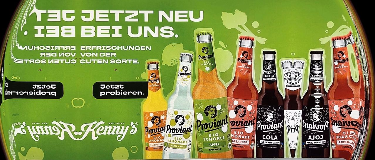Ein Poster mit vier Flaschen Proviant Limonade. Eine Flasche ist Limette und Minze, eine andere ist Apfel, eine ist Bio Schorle und die letzte ist Bio Limonade.