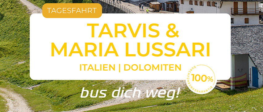 Ein malerisches Panorama von Tarvis und Maria Lussari in Italien, Dolomiten, mit einem Dorf und einer Kirche auf einem Hügel. Ein Feldweg führt zum Dorf. Der Text lautet 'Tagesfahrt Tarvis & Maria Lussari, Italien, Dolomiten' zusammen mit einem Logo.