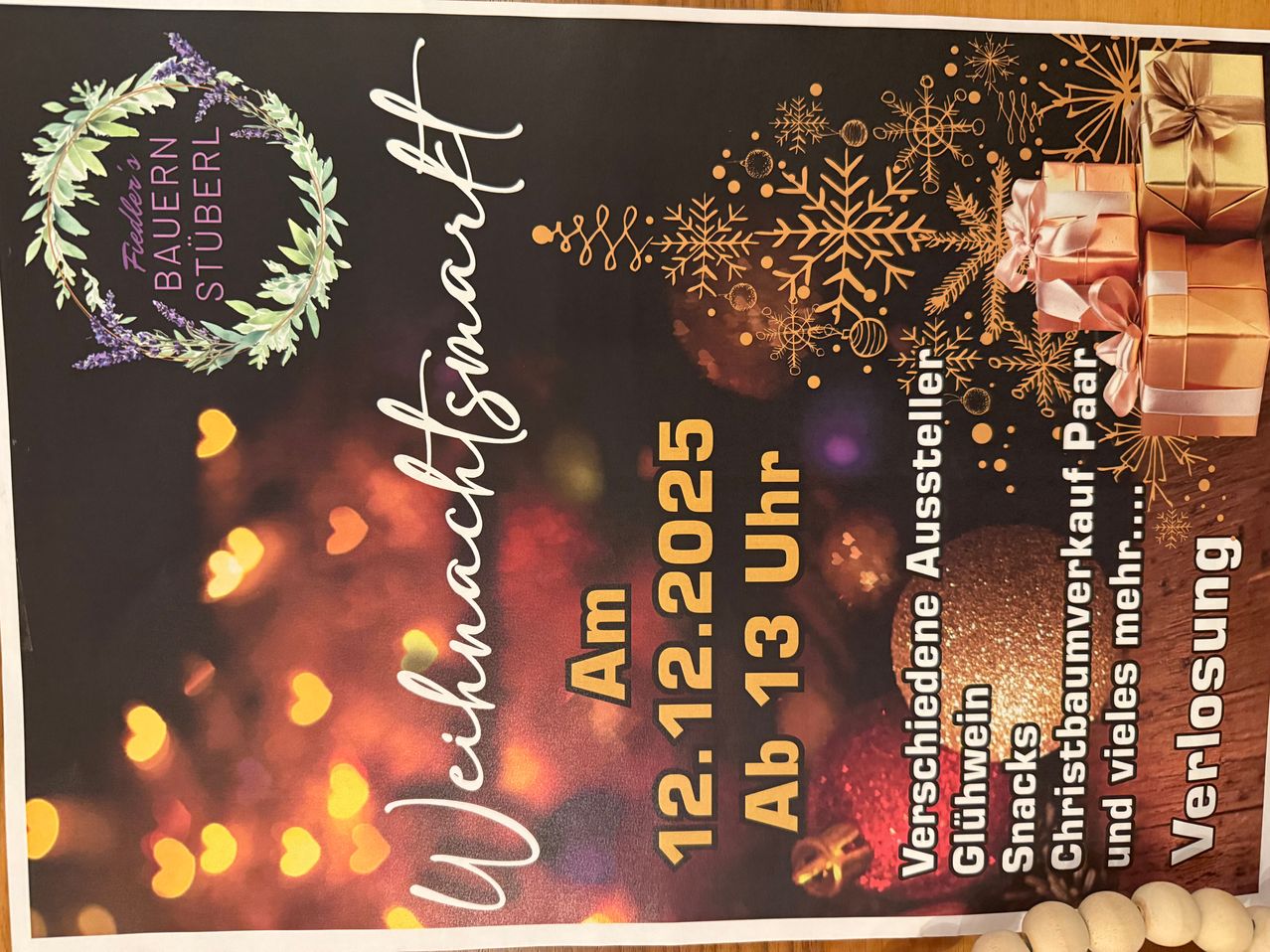 Werbung für einen Weihnachtsmarkt mit festlichen Dekorationen, darunter Schneeflocken, Ornamente und ein Geschenk. Der Text lautet 'Am 12.12.2025 Ab 13 Uhr', was auf eine Veranstaltung am 12. Dezember 2025 um 13 Uhr hinweist.