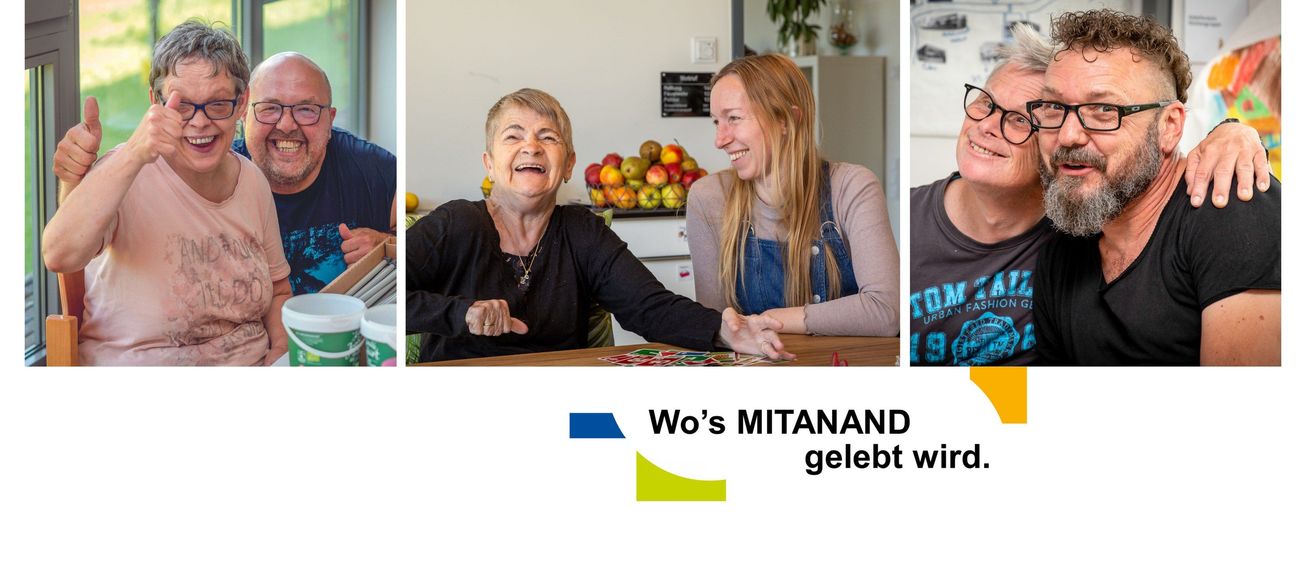 Zwei Frauen sitzen lächelnd am Tisch, eine mit langen blonden Haaren, die andere mit kurzen grauen Haaren. Dahinter steht ein Tisch mit Obst.