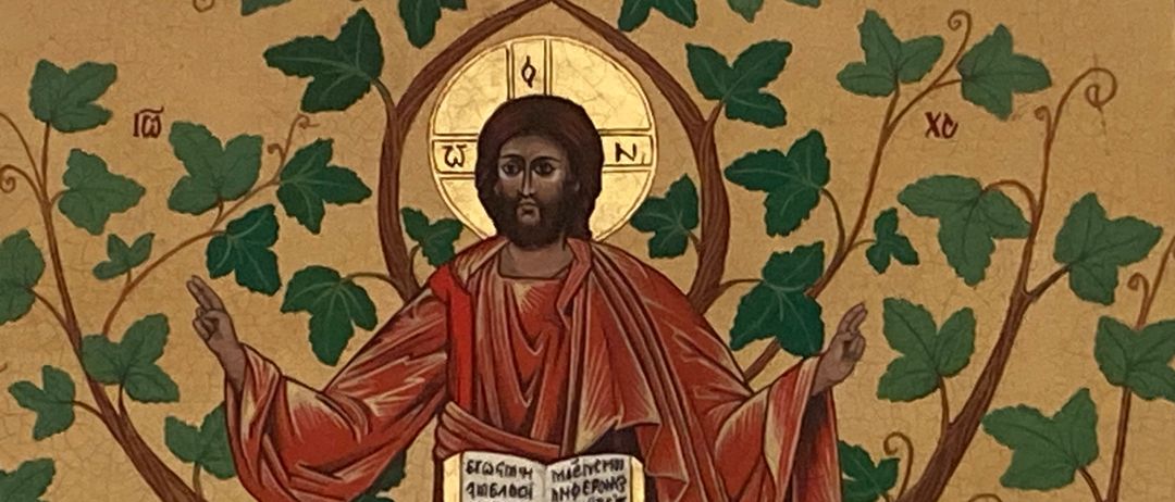 Eine Darstellung von Jesus, der auf einem Ast sitzt und ein Buch in der Hand hält. Der Hintergrund ist golden mit Efeublättern.