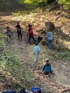 Eine Gruppe von Kindern gräbt in der Erde auf einem Waldweg.