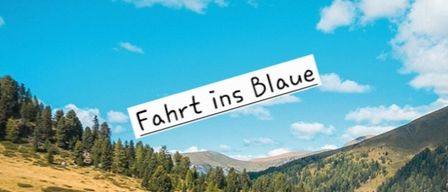 Eine landschaftliche Bergszene mit blauem Himmel und Wolken. Der Text 'Fahrt ins Blaue' ist überlagert und deutet auf eine Reise ins Blaue hin.