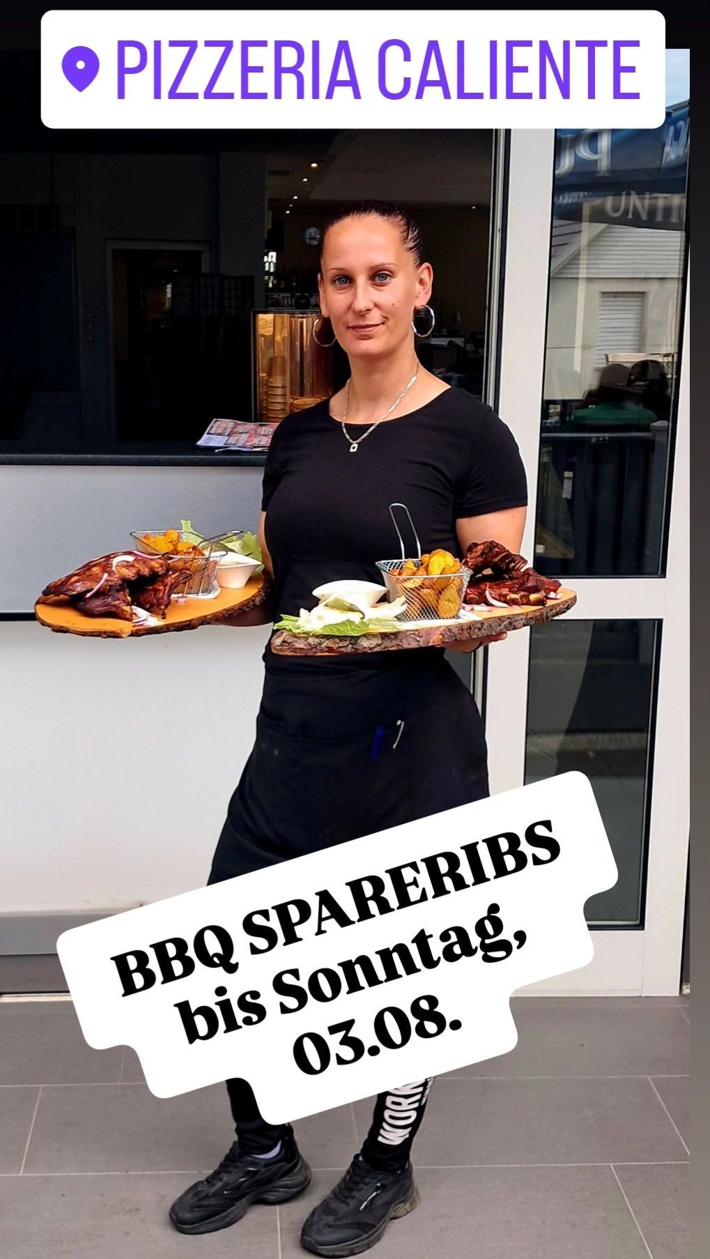 Eine Frau steht vor einem Restaurant und hält zwei Holzplatten mit verschiedenen Speisen. Sie trägt ein schwarzes Shirt und eine Schürze. Das Bild hat eine weiße Überlagerung mit dem Text BBQ Spareribs Sonntag.