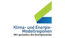 Das Bild zeigt ein Logo für Klima- und Energie-Modellregionen mit einem grünen und blauen Symbol und Text in fetter schwarzer Schrift. Die Organisation zielt darauf ab, die Energiewende zu gestalten.