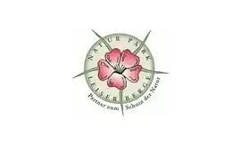 Das Logo für Natur Park Leiser Berge zeigt eine rosa Blume in der Mitte, umgeben von einem Kompass mit Himmelsrichtungen, und die Worte 'Partner zum Schutz der Natur' in einem kreisförmigen Muster geschrieben.