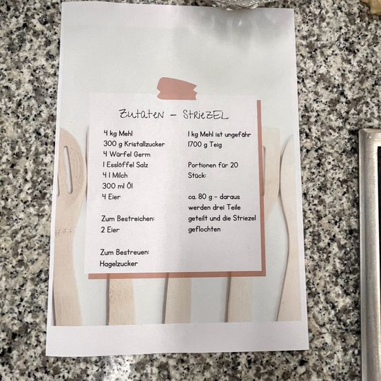 Ein Blatt Papier mit dem Titel 'Zutaten - STRIEZEI' listet Zutaten für ein Rezept auf, einschließlich Mehl, Kristallzucker, Hefe, Salz, Milch, Öl und Eier. Es gibt Portionsgrößen und Mischanweisungen.