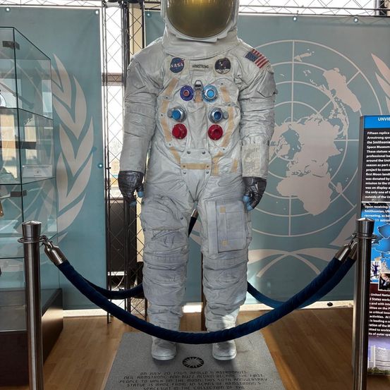 Eine Replik von Neil Armstrongs Apollo 11 Raumanzug, der erste, der von einem Menschen auf dem Mond getragen wurde, wird auf einem Podest in einer Ausstellung gezeigt, umgeben von einem blauen Seilzaun.