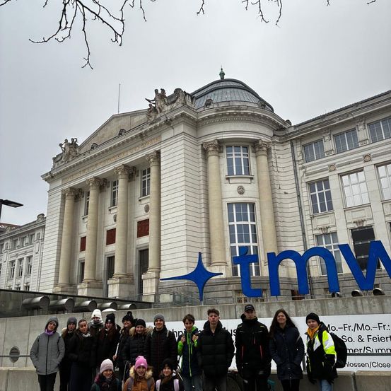 Eine Gruppe von Menschen steht vor dem Technischen Museum in Wien, Österreich. Das Museum hat eine klassische Architektur mit einer Kuppel und großen Säulen.