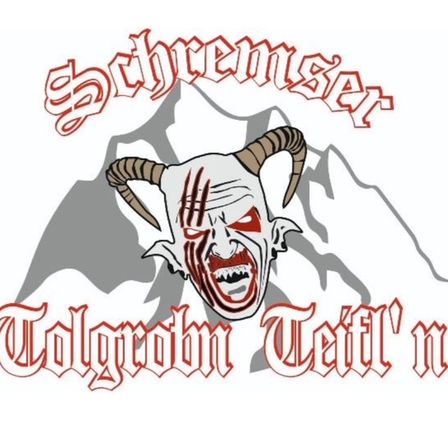 Ein Logo mit einem stilisierten, hörnertragenden Dämonengesicht mit Blutspuren und einem Bergsilhouetten-Hintergrund, begleitet von dem Text 'Schremser Tolgrohrn Teufel'n' in gotischer Schrift.