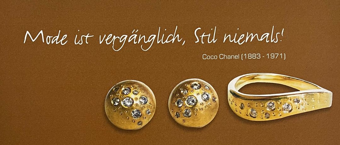 Eine braune Einladungskarte mit einem Zitat von Coco Chanel, 'Mode ist vergänglich, Stil niemals!' und einem Foto von Goldschmuck. Die Karte lädt zur Eröffnung einer Ausstellung am Freitag, 21.11.2025 ein. Die Ausstellung ist täglich bis zum 24. Dezember, 13:00 Uhr geöffnet. Öffnungszeiten: Montag bis Donnerstag von 14:00 bis 18:00 Uhr, Freitag von 9:00 bis 12:00 und 13:00 bis 18:00 Uhr und Samstag von 9:00 bis 12:00 Uhr.