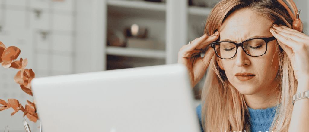 Eine Frau arbeitet an einem Laptop und scheint gestresst zu sein, mit den Händen auf dem Kopf. Das Poster bewirbt eine Veranstaltung am 19. März. Unten im Poster befinden sich Logos verschiedener Organisationen.