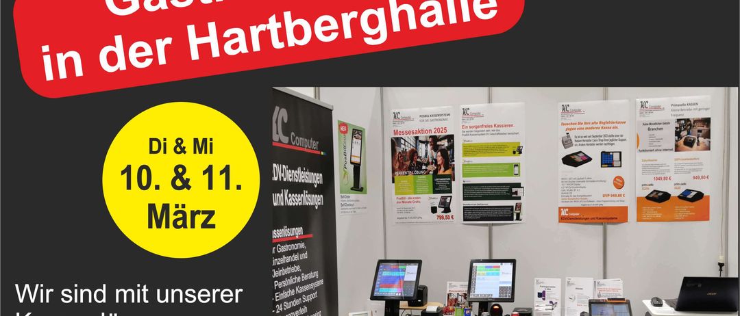 Eine Werbung für die Gastro Messe der Hartberghalle. Es zeigt einen Banner mit einem gelben Kreis, auf dem 'Di & Mi 10. & 11. März' steht. Unter dem Banner befinden sich Tische mit Computern, Monitoren und anderen Geräten. Poster hängen an der Wand.