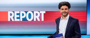 Ein Mann in einem Anzug steht vor einem Bildschirm mit dem Wort Bericht darauf. Er hält eine blaue Karte mit dem Wort Bericht darauf.