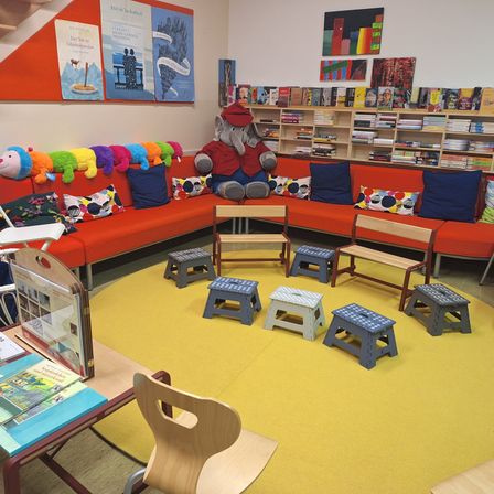 Bild enthält, Kindergarten, Chair, Furniture, Building, Couch, Person, Indoors, Living Room, Play Area, Library