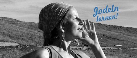 A woman in a sleeveless shirt and bandana stands in a grassy field with mountains in the background. She looks up with her hand near her face. The text 'Jodeln lernen!' is written in blue.